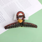 Fermaglio per capelli in acrilico incrociato con toppa rotonda