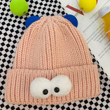 Simpatico cappello lavorato a maglia per bambini con occhi da cartone animato color caramello - rosa