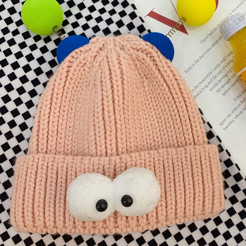 Simpatico cappello lavorato a maglia per bambini con occhi da cartone animato color caramello - rosa
